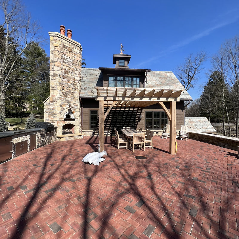 HPC Di Napoli Ready-to-Finish pizza oven built into a stone outdoor fireplace and kitchen on a brick patio