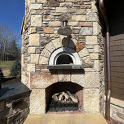 Close-up of a stone-finished HPC Di Napoli pizza oven arch with wood storage below