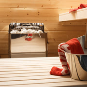 Harvia The Wall sauna heater with steel sauna bucket and ladle on the bench