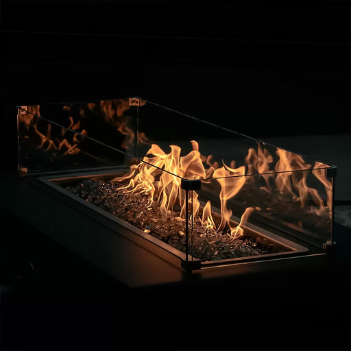Close-up of The Outdoor Plus glass wind guard panels around a round gas fire pit, satin black metal frame