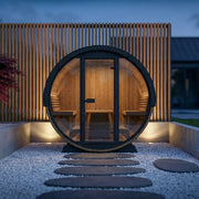 SaunaLife EE8G barrel sauna lit up at night in a modern backyard