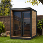 SaunaLife GL4 outdoor sauna installed in a landscaped backyard garden at dusk