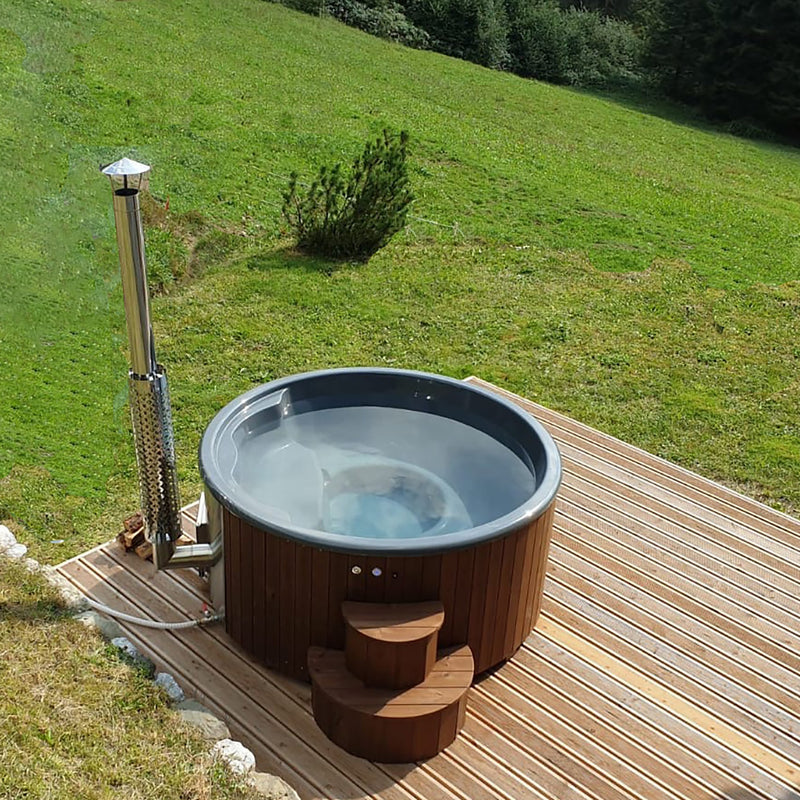 SaunaLife S4N wood-fired hot tub filled and heating on a hillside deck