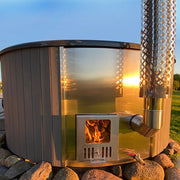 SaunaLife Model S4N wood burning hot tub with wooden exterior and open seating, set outdoors on a natural landscape.
